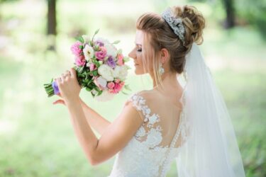 charming-bride-poses-with-colorful-wedding-bouquet-park_8353-4008